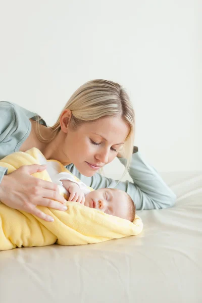 그녀의 잠자는 아기 옆에 누워 어머니 — 스톡 사진