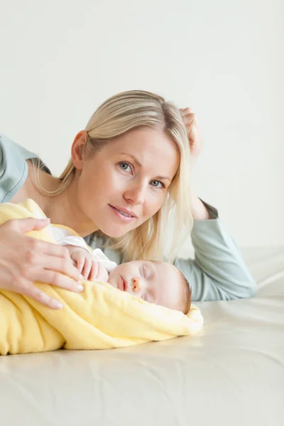 眠っている赤ん坊の横に横になっているお母さん — ストック写真