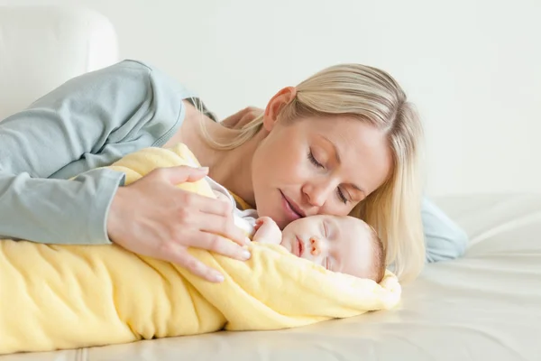 Мати розслабляється поруч зі своєю сплячою дитиною — стокове фото