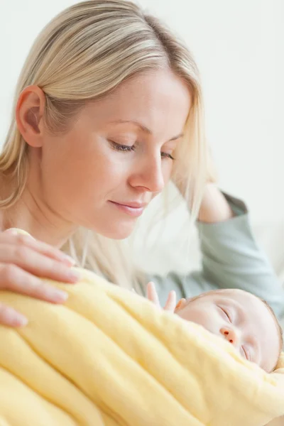 Mãe descansando ao lado de seu bebê adormecido — Fotografia de Stock