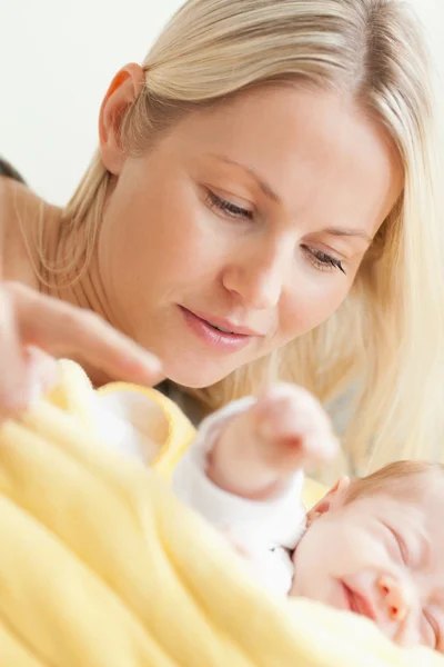 Close up of mother relaxing next to her sleeping baby — Stock Photo, Image
