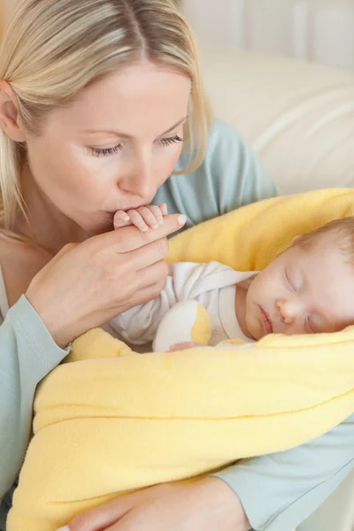 Primer plano de la madre besando la mano de su bebé — Foto de Stock
