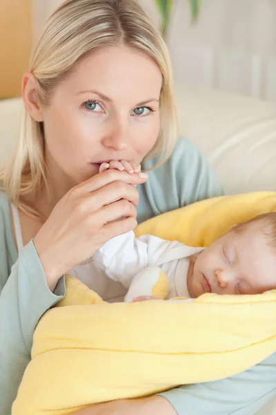Primer plano de madre cariñosa besando la mano de su bebé — Foto de Stock