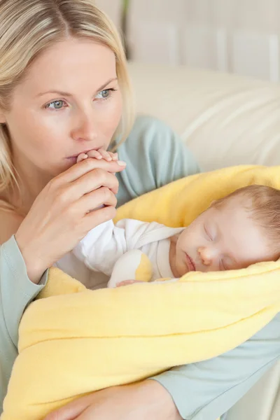 Nahaufnahme einer fürsorglichen Mutter, die die Hand ihres Babys küsst — Stockfoto
