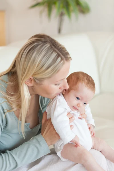 Matka na pohovce, drží své dítě — Stock fotografie