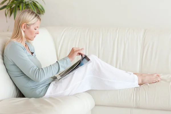 女人在她的沙发上阅读的侧视图 — 图库照片