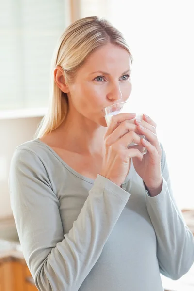 Woman drinking a glass of water in the kitchen — Stock Photo, Image