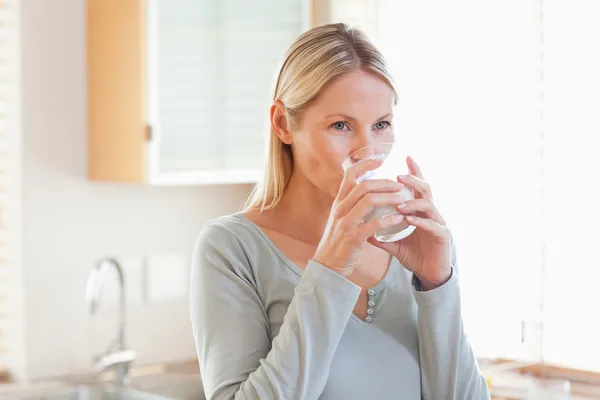Frau in der Küche trinkt Wasser — Stockfoto