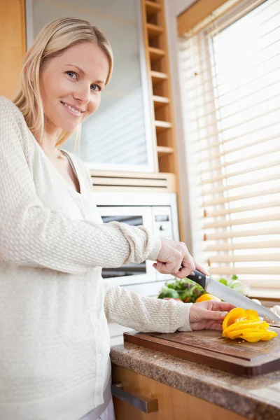 Smiling woman slicing pepper bell — Stock Photo, Image