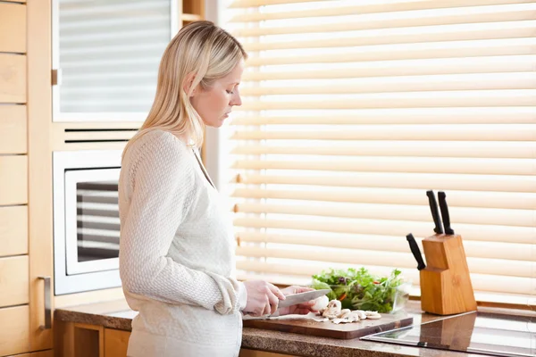 Seitenansicht einer Frau, die Zutaten für ihren Salat schneidet — Stockfoto