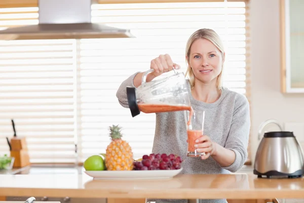Woman pouring smoothie into a glass — Stock Photo, Image