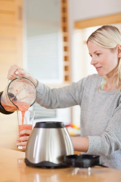 Side view of woman pouring self made smoothie — Stock Photo, Image