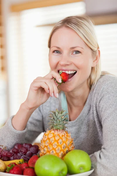Close up of smiling woman having a strawberry — Stock Photo, Image