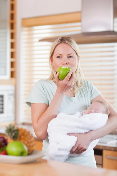 Kollarını bir elma olan bebeği olan kadın — Stok fotoğraf
