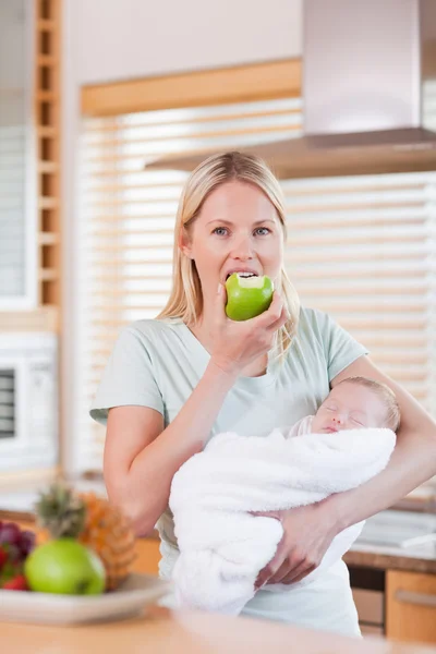 Mother with her newborn having an apple — Stock Photo, Image
