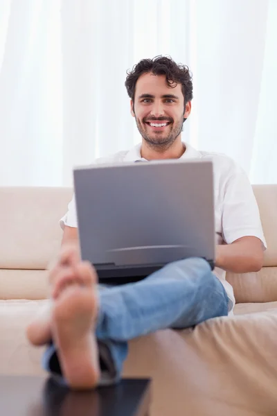 Porträtt av en ung man använder en bärbar dator — Stockfoto
