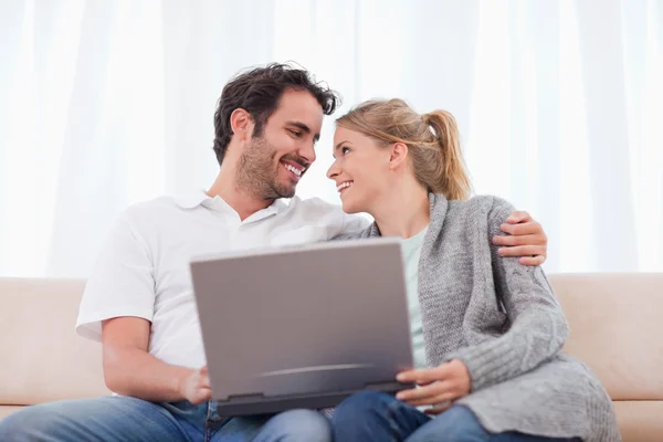Casal feliz usando um laptop — Fotografia de Stock
