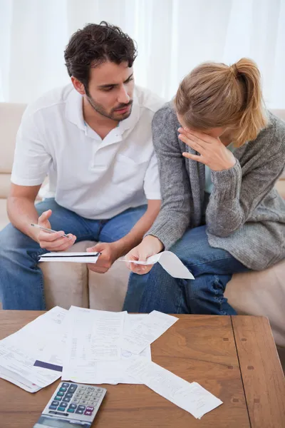 Portrait of a sad couple looking at their bills — Stock Photo, Image