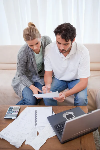 Retrato de una pareja haciendo su contabilidad con un cuaderno — Foto de Stock