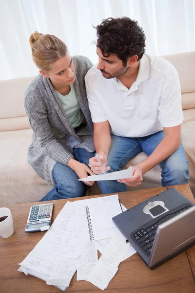 Retrato de una pareja joven haciendo su contabilidad con un bloc de notas — Foto de Stock