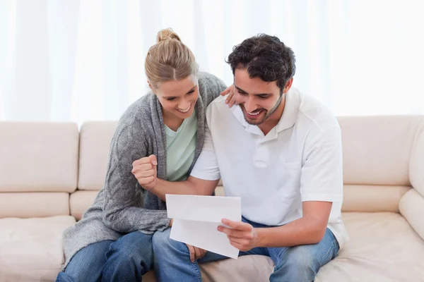 Cheerful couple reading a letter — Stock Photo, Image