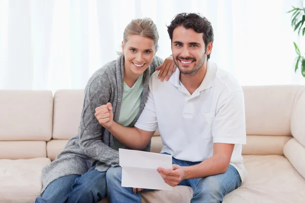 Delighted couple reading a letter — Stock Photo, Image