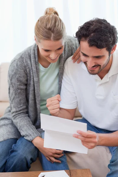 Portrait of a delighted couple reading a letter — Stock Photo, Image