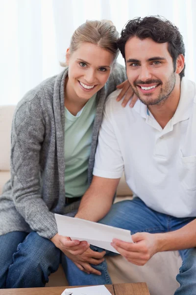 Portrait of a smiling couple reading a letter — Stock Photo, Image