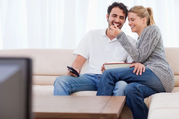 Adorável casal assistindo TV enquanto come pipocas — Fotografia de Stock