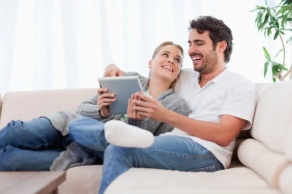 Casal encantado usando um computador tablet — Fotografia de Stock