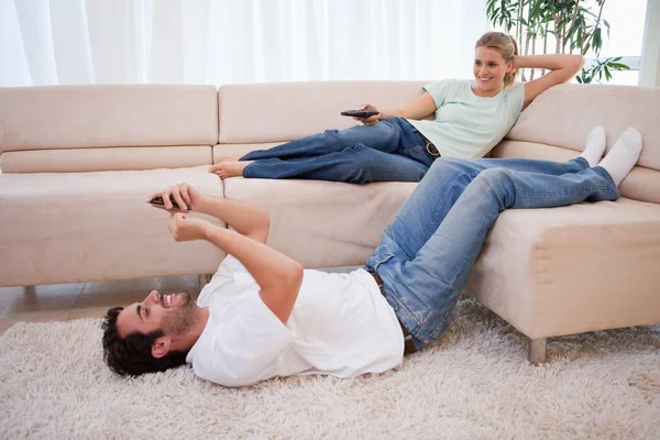 女人看电视，而她的丈夫使用他 cellpho — 图库照片