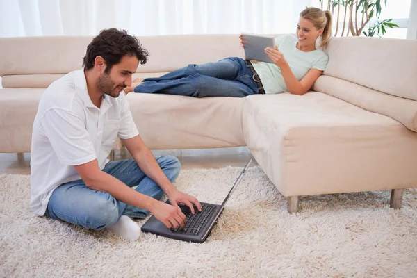 女性彼女の夫が、lapto を使用しているタブレット コンピューターを使用して — ストック写真