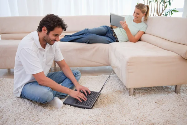 女性は彼女のボーイ フレンドがラップを使用しているタブレット コンピューターを使用して — ストック写真