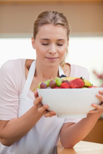 Portrait of a woman smelling a fruit basket — Stock Photo, Image