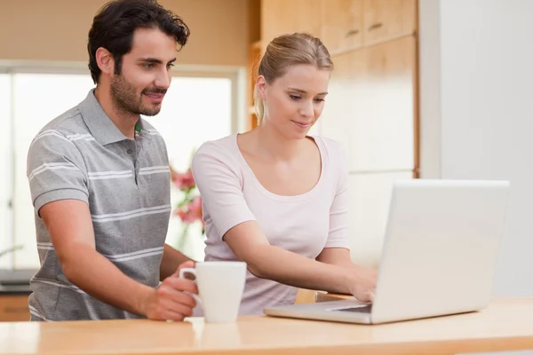 Couple using a laptop while having coffee — Stock Photo, Image