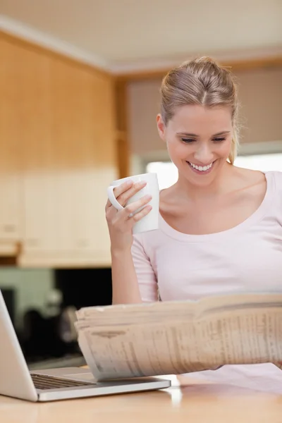 Retrato de una mujer leyendo las noticias mientras toma el té — Foto de Stock