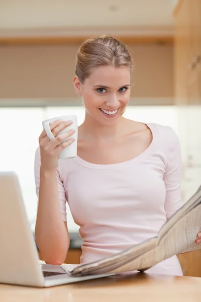 Porträtt av en kvinna läser en tidning med kopp kaffe — Stockfoto