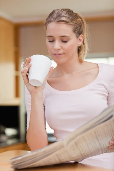 Porträtt av en söt kvinna läsa nyheter samtidigt ha te — Stockfoto