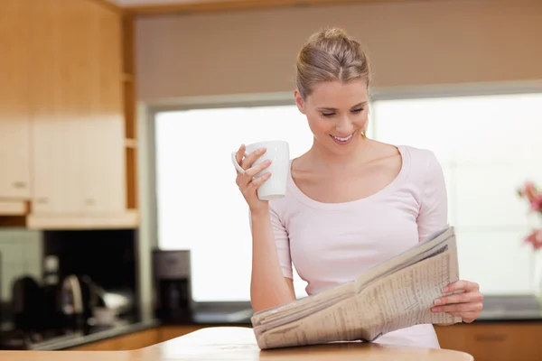 Žena čte zprávy zároveň čaj — Stock fotografie