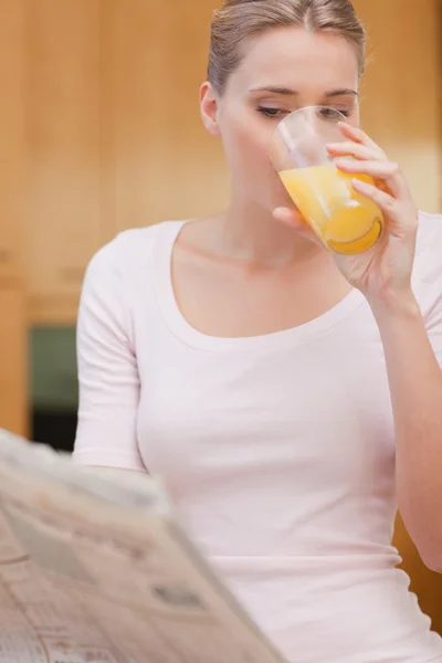 Портрет красивой женщины, читающей новости во время питья джу — стоковое фото