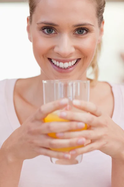 Portrait of a smiling woman drinking juice — Stock Photo, Image