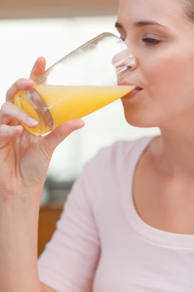 Porträtt av en lugn kvinna dricka apelsinjuice — Stockfoto