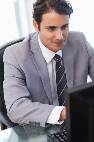 Retrato de um jovem empresário trabalhando com um computador — Fotografia de Stock