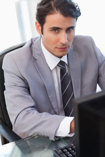 Retrato de un hombre de negocios serio que trabaja con una computadora —  Fotos de Stock