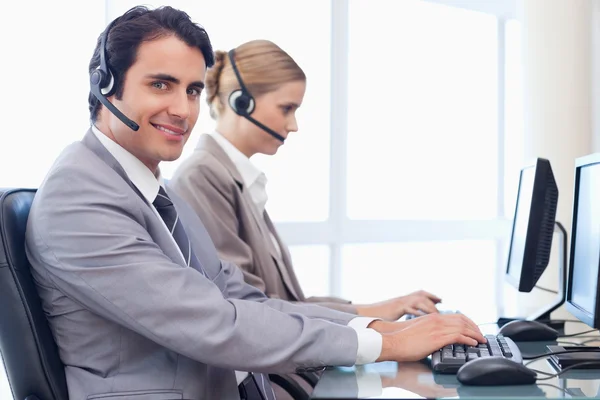 Smiling operators using a computer — Stock Photo, Image