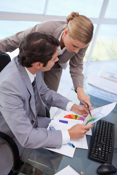 Portret van een manager wijzend op iets aan haar werknemer op een — Stockfoto