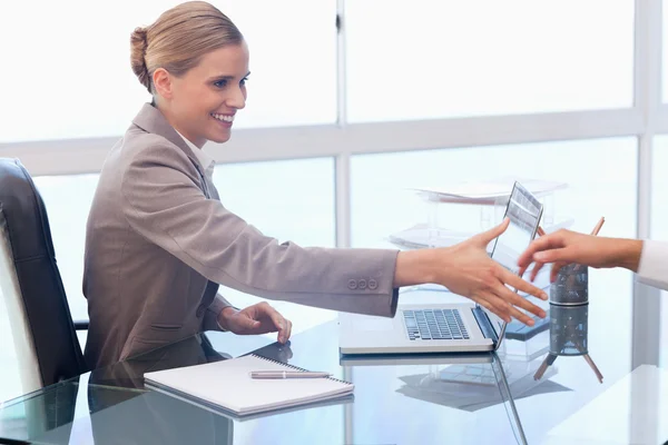 Smiling businesswoman receiving a customer — Stock Photo, Image