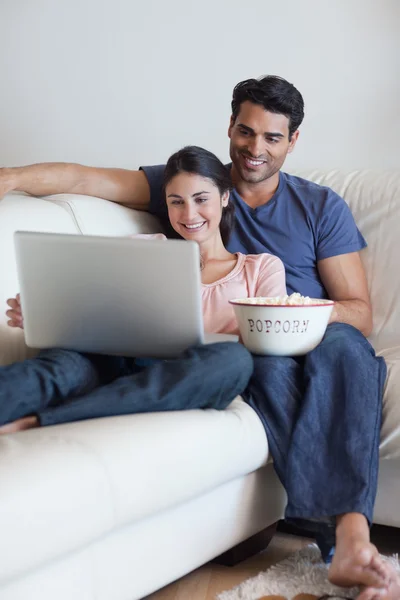 Ritratto di una coppia che guarda un film mentre mangia popcorn — Foto Stock