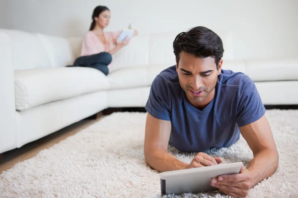 남자가 그의 여자 친구는 보를 읽고는 동안 태블릿 컴퓨터를 사용 하 여 — 스톡 사진