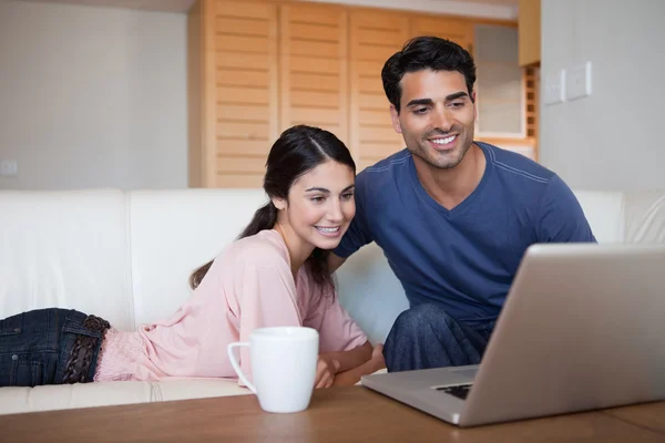 年轻夫妇喝茶的同时使用一台笔记本电脑 — 图库照片